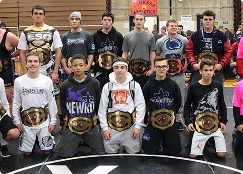 Youth wrestlers with championship belts in gym