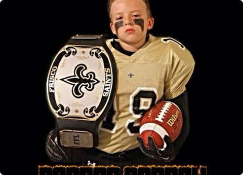 Child football player holding trophy and football