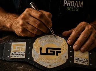 Person working on a championship belt with 'PROAM BELTS' branding.