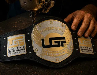 United Graphic Federation championship belt held by a person with a sewing machine